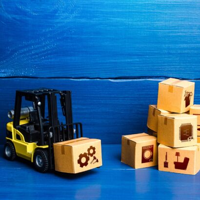 Forklift truck and cardboard boxes with goods. Logistic infrastructure and warehousing services