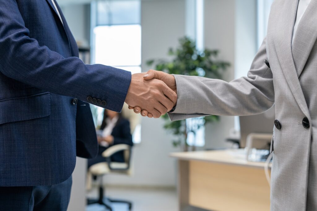 Handshake of two young business partners in office environment